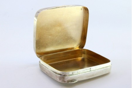  Caixa de comprimidos em prata guilhochada com interior dourado e tampa basculante.